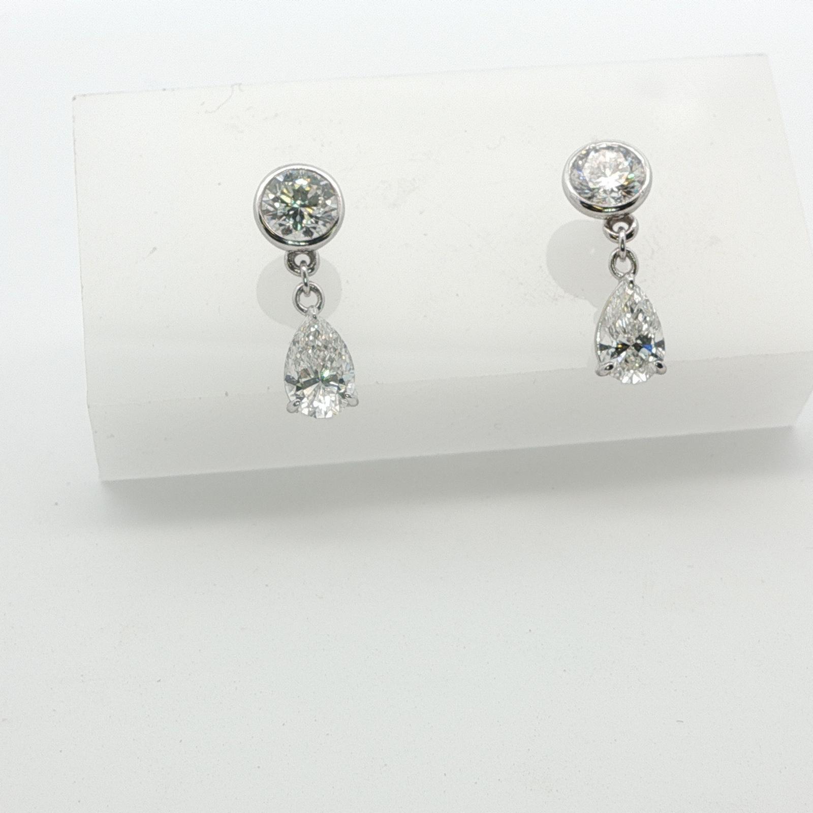 Drop earrings are lab created rounds and pear shapes set in 14k white gold