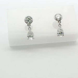 Drop earrings are lab created rounds and pear shapes set in 14k white gold
