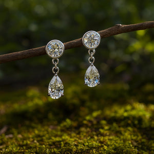 Drop earrings are lab created rounds and pear shapes set in 14k white gold