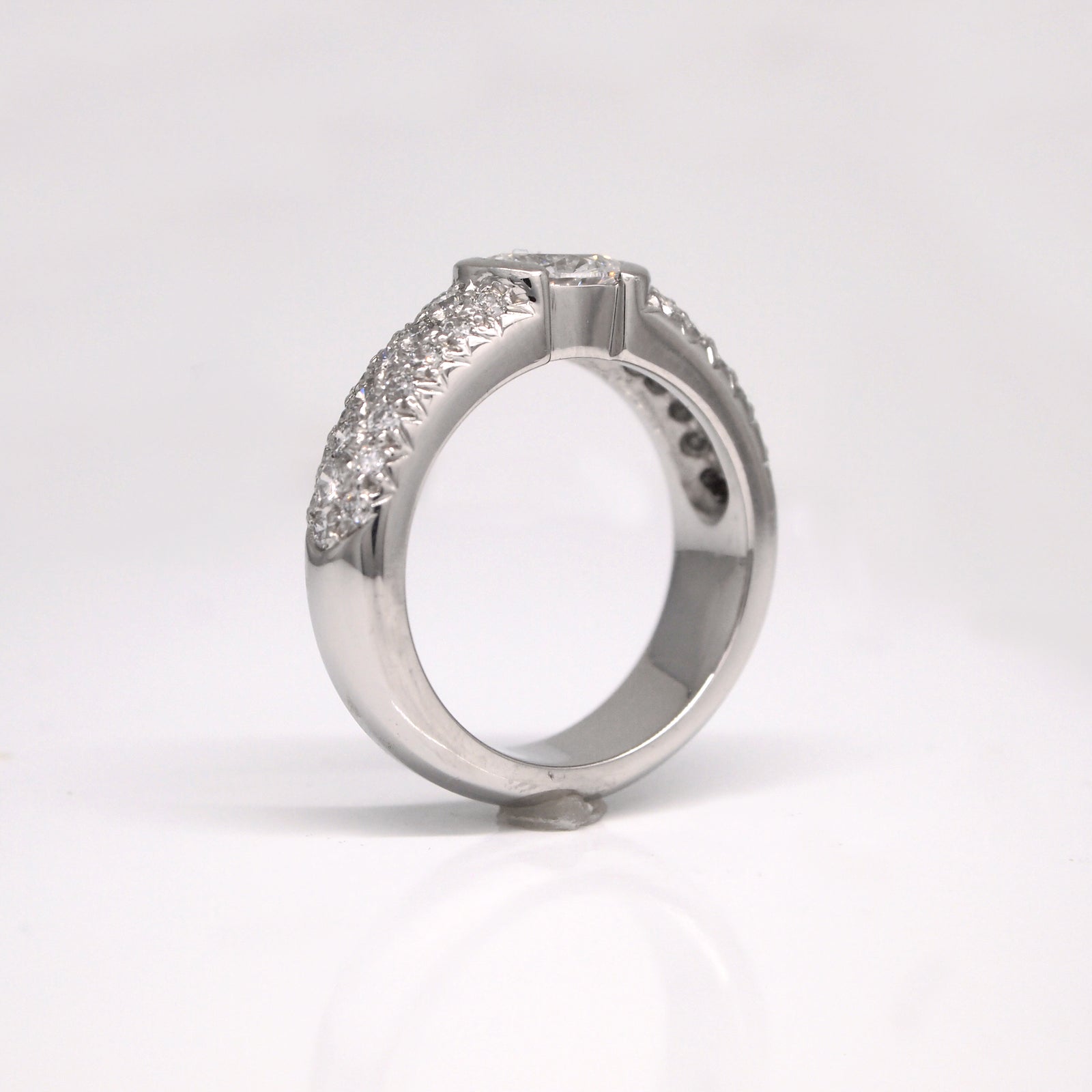 Platinum diamond engagement ring featuring one 0.70 carat oval diamond (SI1, E color), and pave set diamonds weighing a total of 0.75 carats.