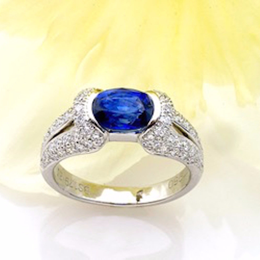 Platinum sapphire ring with one oval sapphire and pave set diamonds 
