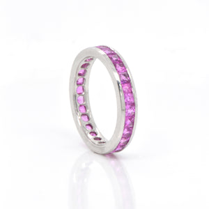 Platinum sapphire eternity band featuring princess-cut pink sapphires (2.43ctw) channel set in bright, white platinum in a full eternity design. 