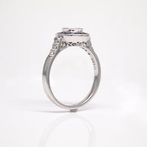 18K white gold sapphire and diamond engagement ring with one 0.42 carat round brilliant-cut diamond, baguette-cut sapphires weighing a total of 0.42 carats, and round brilliant-cut diamond weighing a total of 0.07 carats. 