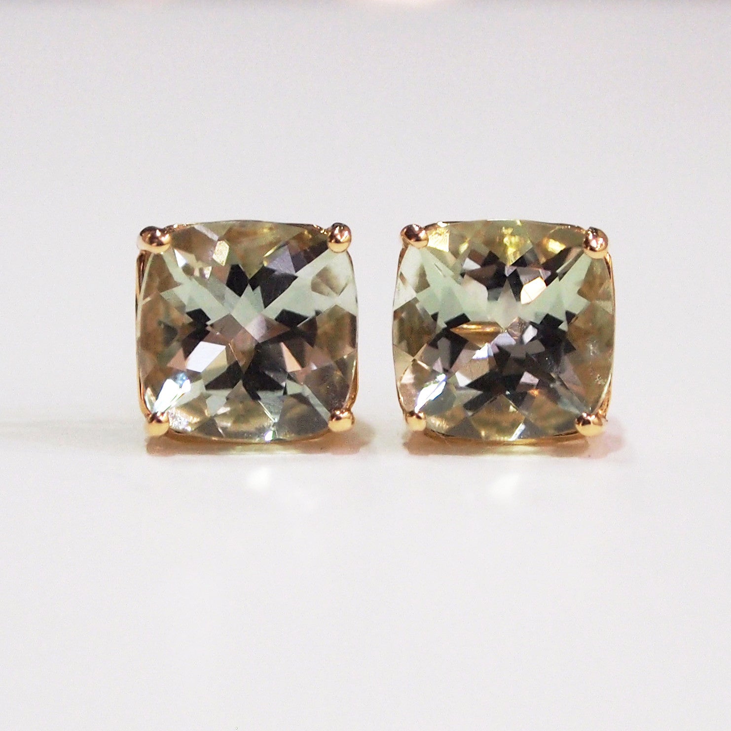 14K yellow gold four-prong stud earrings with two cushion-cut green amethysts