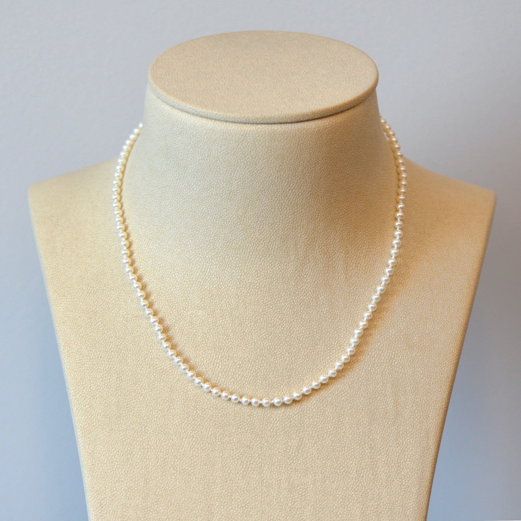 Pearl strand necklace featuring round freshwater pearls (4mm) and a 14K white gold marquis-shaped clasp. 