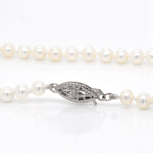 Pearl strand necklace featuring round freshwater pearls (4mm) and a 14K white gold marquis-shaped clasp. 