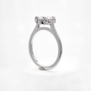 Platinum engagement ring featuring a crescent halo with round brilliant diamonds weighing a total of 0.04 carats. This