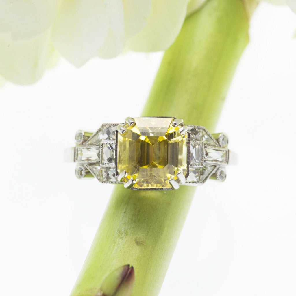Side view of one natural unheated, untreated asscher-cut yellow sapphire weighing 3.92 carats set in a platinum antique setting, ring