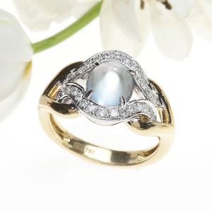 Angled View of White and Yellow Gold Two Tone Cabochon Cut Moonstone Ring with Round Brilliant Diamonds