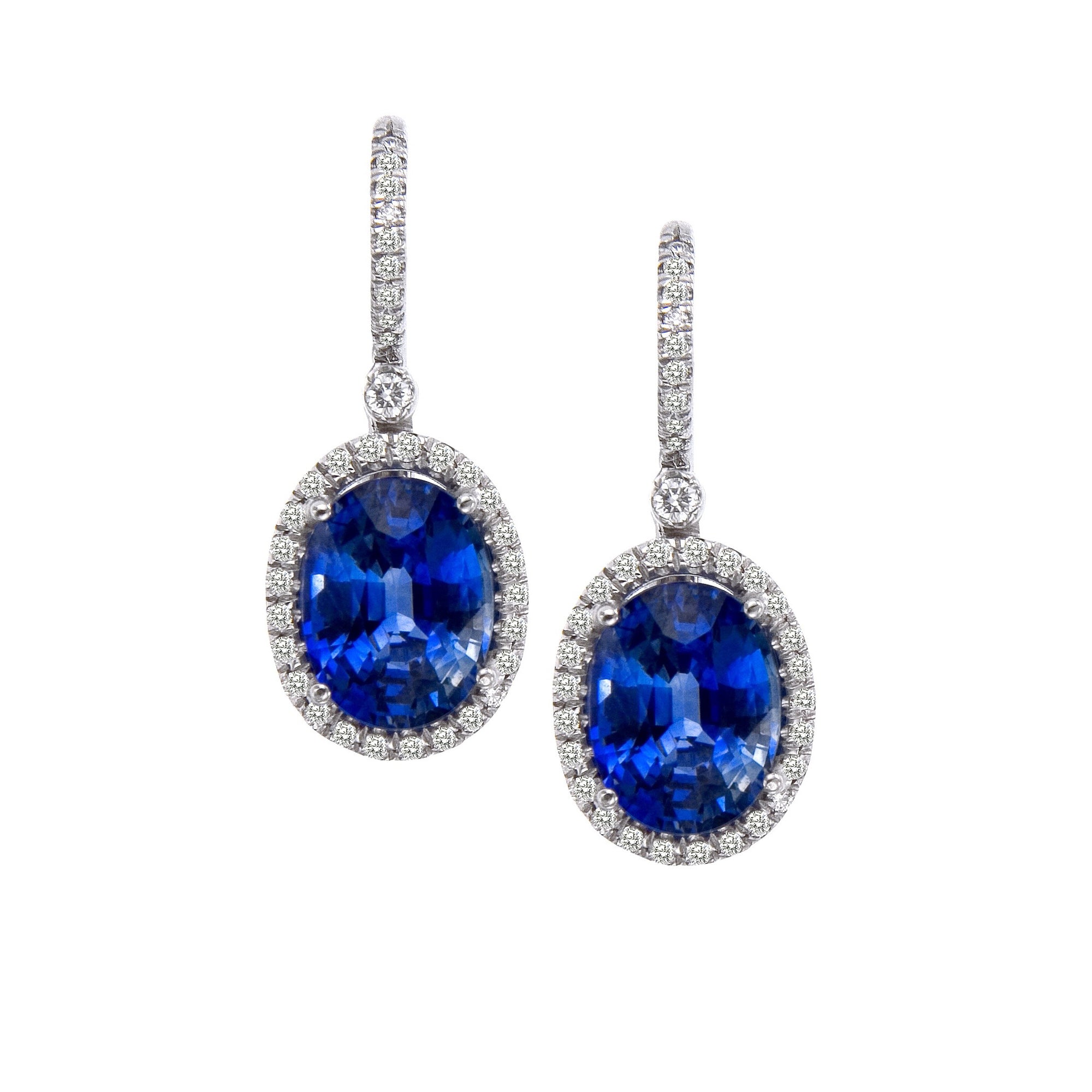 18K white gold sapphire and diamond earrings featuring 2 oval sapphires, and round brilliant diamonds set in a drop earring design. 