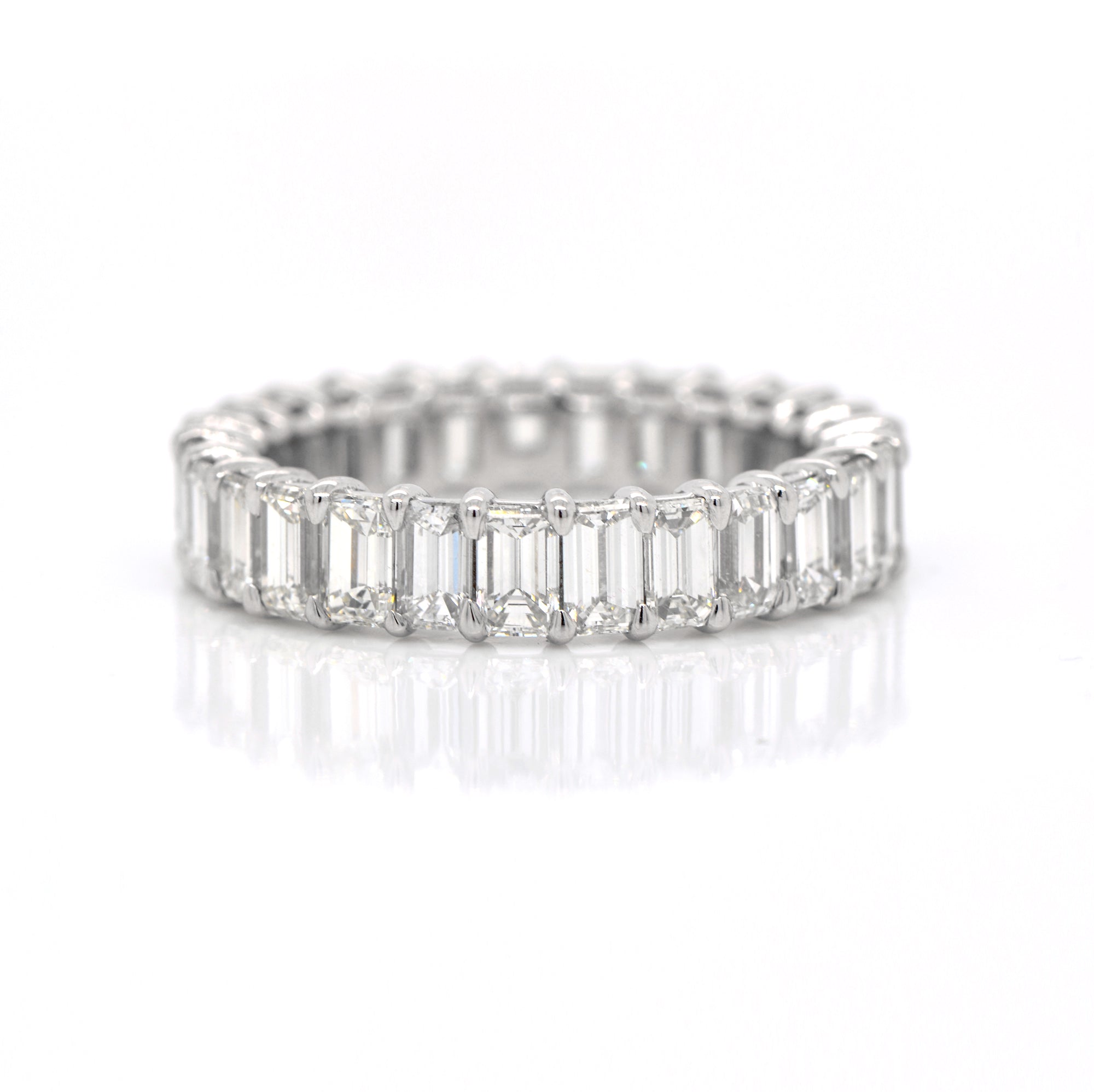 Platinum diamond eternity band featuring 27 emerald-cut diamonds (H color, VS clarity) weighing a total of 4.26 carats.