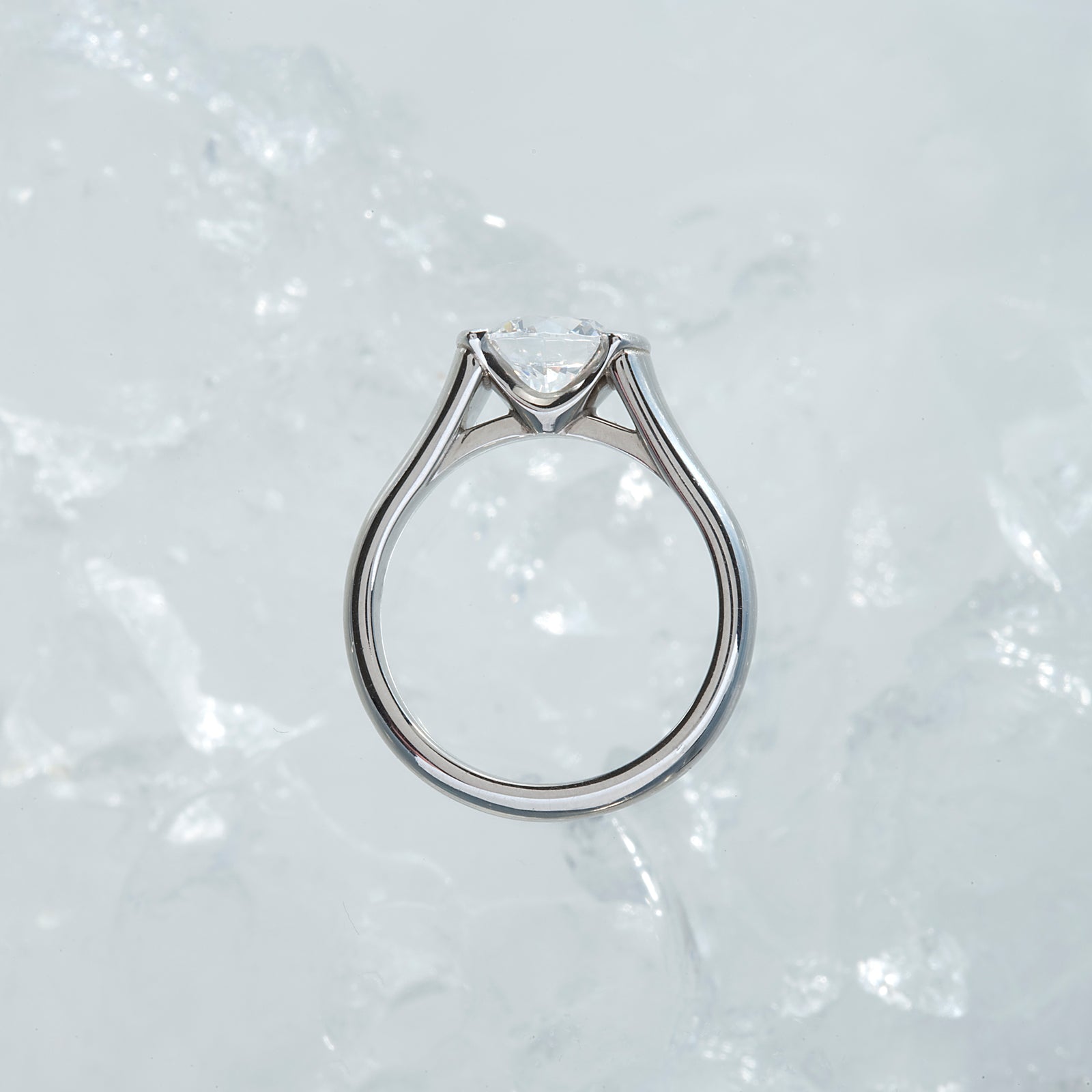 Diamond engagement ring featuring a round brilliant-cut diamond. and channel-set princess-cut diamonds. Custom-made to order for any size diamond or gemstone center stone. Available in 14K or 18K white, yellow, rose gold, and platinum. 