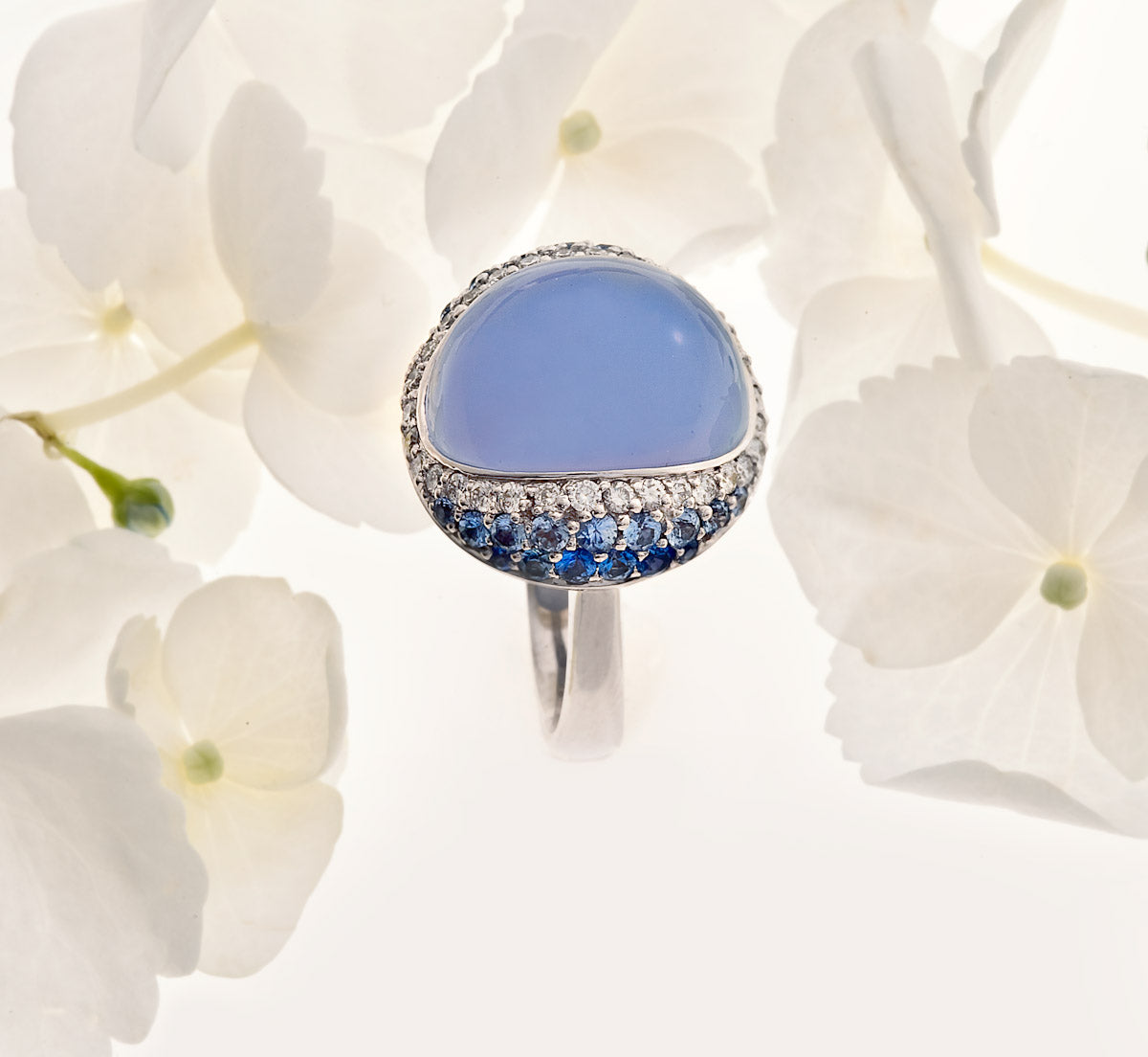 white gold cabochon-cut blue calcedony ring with pave set sapphires and diamonds
