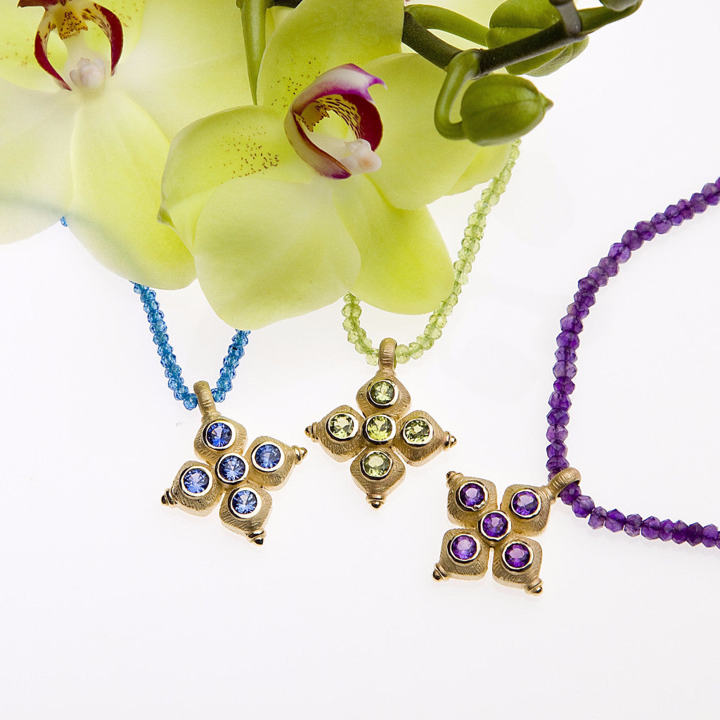 Yellow gold pendant set with 5 round peridots on a peridot briolette necklace