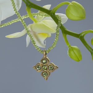 Yellow gold pendant set with 5 round peridots on a peridot briolette necklace