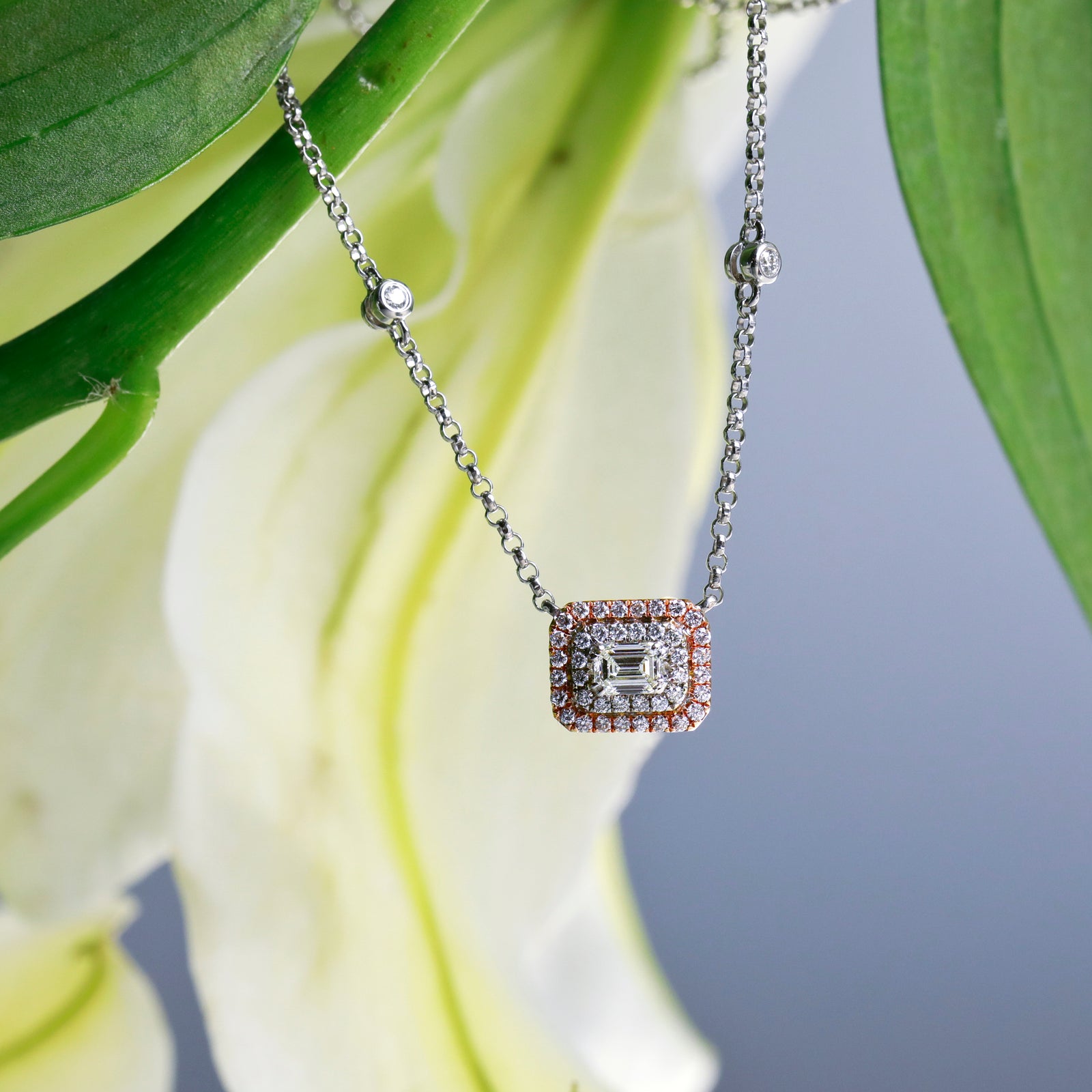 14K rose gold and white gold necklace with 1 emerald-cut diamond weighing 0.31 carats, and 42 brilliant cut diamonds weighing a total of 0.30 carats.