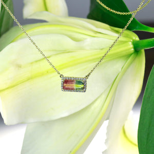 Custom designed 16-inch 14K yellow gold necklace featuring one 2.47 carat green/pink watermelon tourmaline, and a diamond halo with round brilliant diamonds weighing a total of 0.21 carats.
