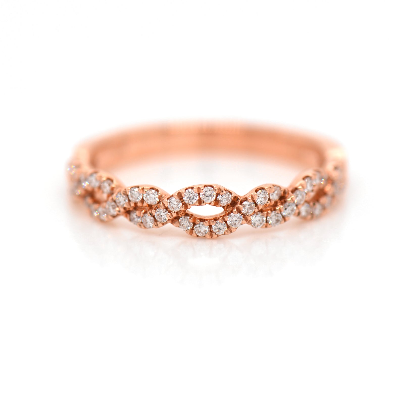 14K rose gold diamond band featuring round brilliant diamonds weighing a total of 0.26 carats set in an interwoven twist design. 