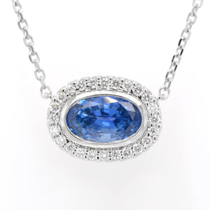 14K white gold sapphire and diamond necklace featuring one 2.90 carat oval blue sapphire set East-West in a diamond halo (0.24ctw).