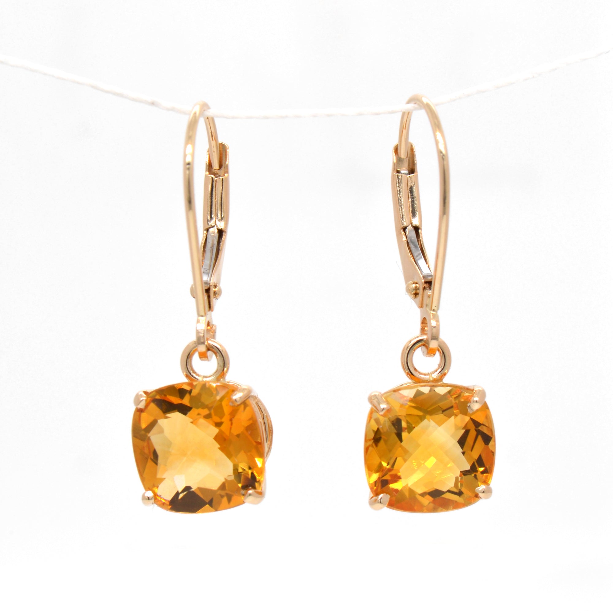 14K yellow gold citrine earrings featuring 2 golden yellow-orange cushion-shaped citrines measuring 8x8 mm.