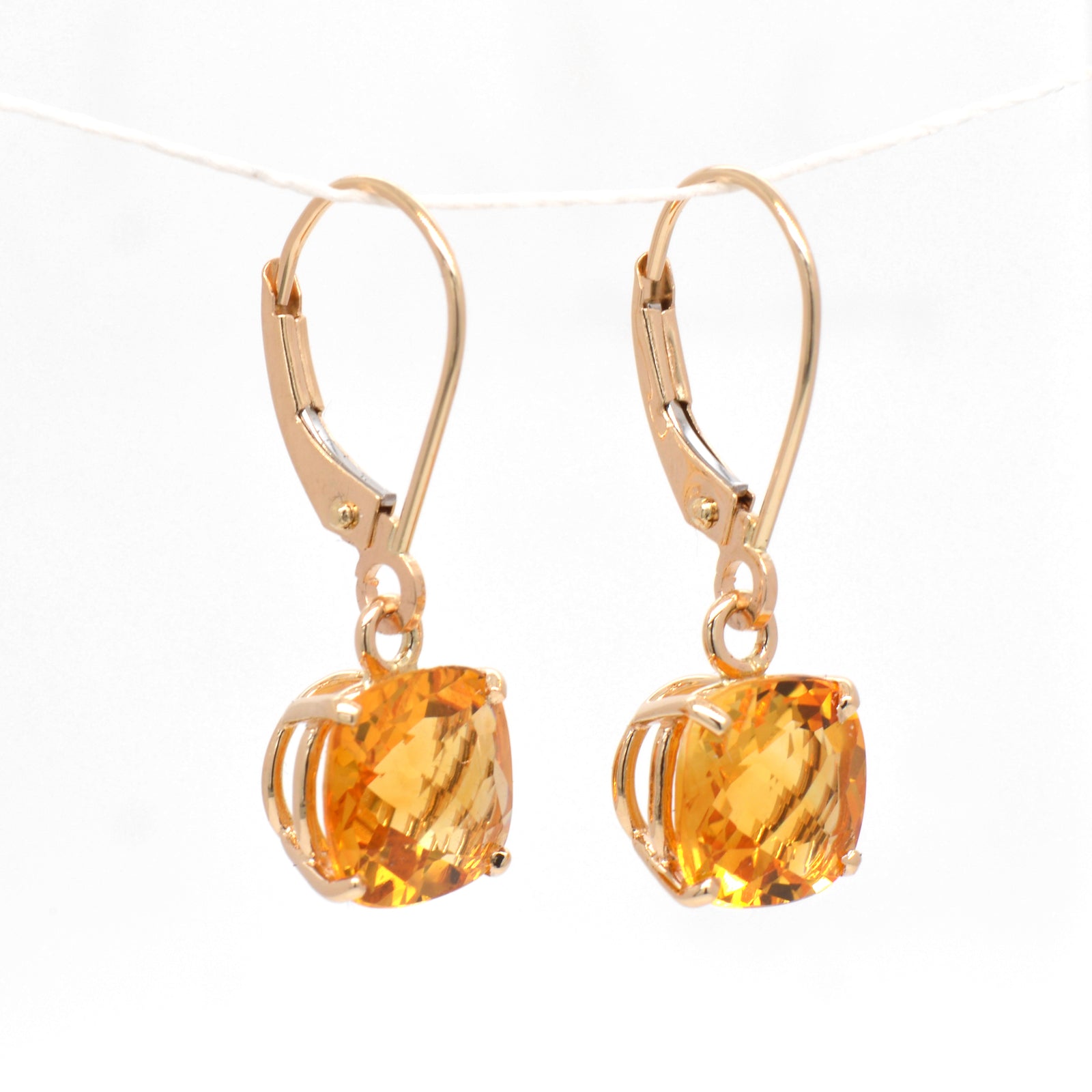 14K yellow gold citrine earrings featuring 2 golden yellow-orange cushion-shaped citrines measuring 8x8 mm.