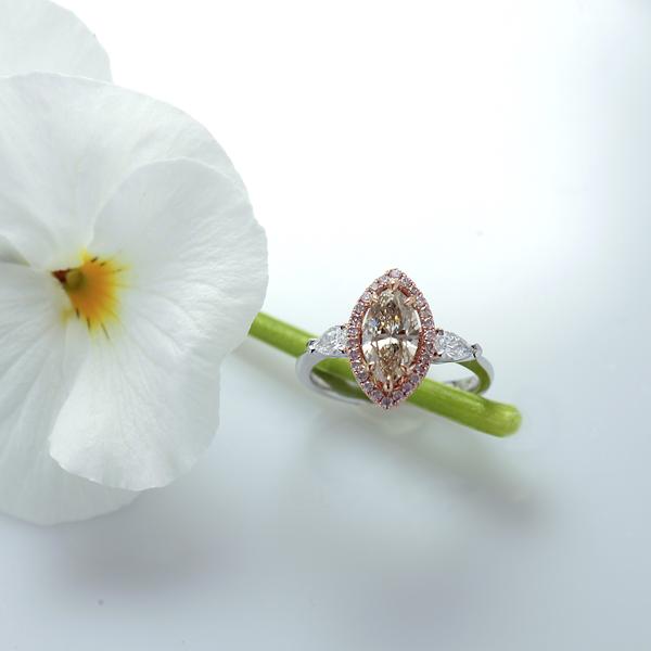 14K white gold diamond engagement ring featuring 1 champagne marquis diamond in a halo of round brilliant pink diamonds, and 2 pear shaped diamond set in a 3-stone design. Custom made to order for any size diamond or gemstone center stone. Available in 14K or 18K white, yellow, rose gold, and platinum.